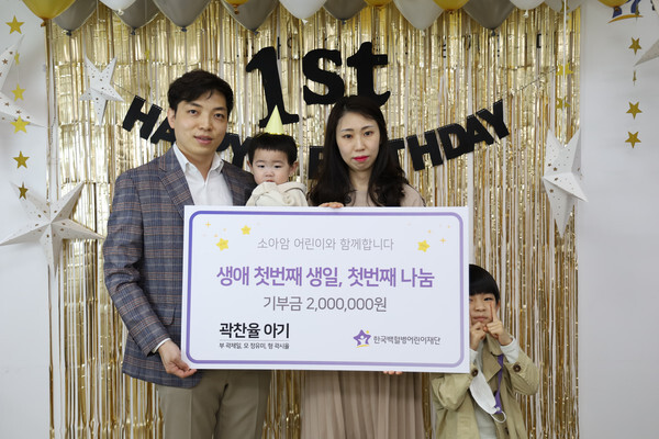 사진: 곽제일·정유미 부부가 아들 찬율군과 첫돌 기부금을 전달하고 기념 촬영을 하고 있다. [제공 = 한국백혈병어린이재단]