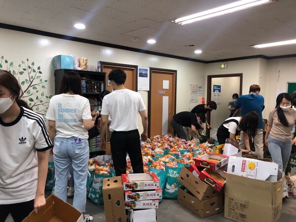 사진: 성민재가노인복지센터 직원과 팀솔그리 단원들이 식료품 키트 ‘행복보따리’를 포장하고 있다.