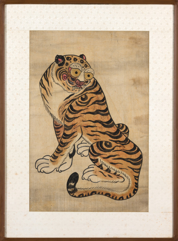 사진: 민화호도(民畵虎圖), 한국 광복이후, 종이, 전체길이 110.2 전체너비 81.4, 세로 81.8, 가로 54.0, 국립중앙박물관, 서울, 대한민국. 광복 이후에 그려진 것으로 추정되는 호랑이를 주제로 한 민화. 부드럽고 생동감 있는 필치는 자연스레 화면 속으로 빨려 들어가게 한다. 액운을 막아주는 호랑이와 함께 호랑이 기운을 듬뿍 받아보자. [제공 = 아트램프]